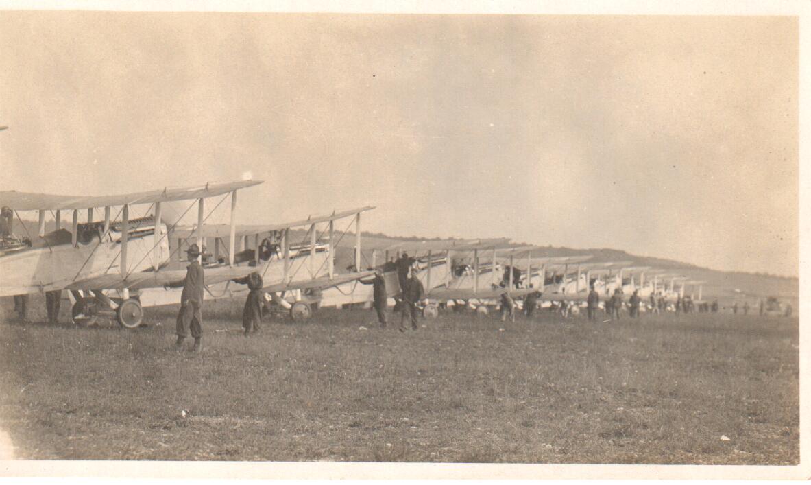 About fifteen DH-4s lined up, receding in perspective from close up at left to barely visible at right.