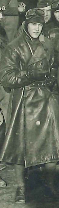 Full-length photo of man in leather flying coat and helmet, evidently a detail from a larger photo.