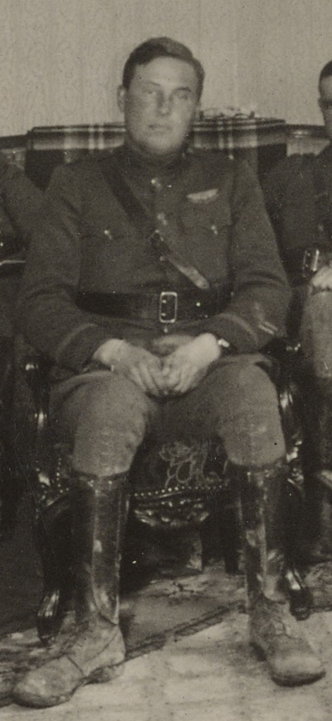 Foss, in uniform, with muddy boots,looking tired and pensive, sitting in rather ornate chair.