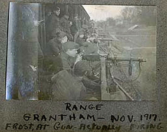 A poorly reproduced black and white photo showing a line of men at machine guns receding into the distance, with the caption "Range Grantham, Nov. 1917, Frost at Gun actually firing."