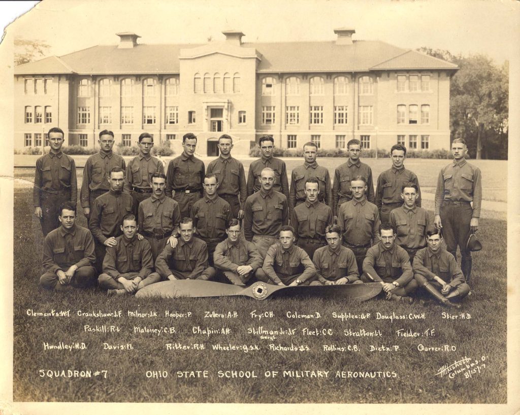 Photo of 25 men seated and standing on grass before a large academic building with an airplane propeller in front of them, with their names handwritten in and the legend "Squadron # 7 Ohio State School of Military Aeronautics."