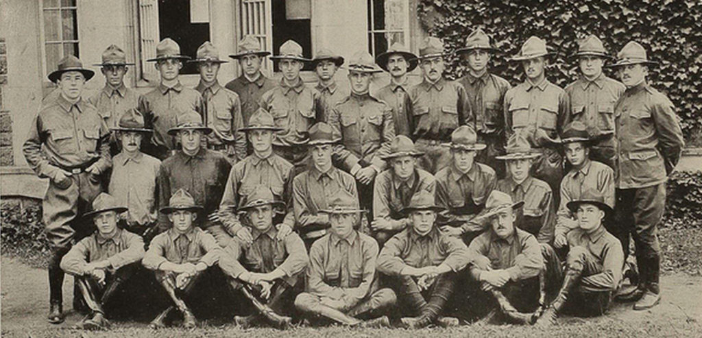 Photo of 29 men in uniform wearing campaign hats, arranged in three rows; the men in the front row are sitting, the men in the middle and back rows are standing.